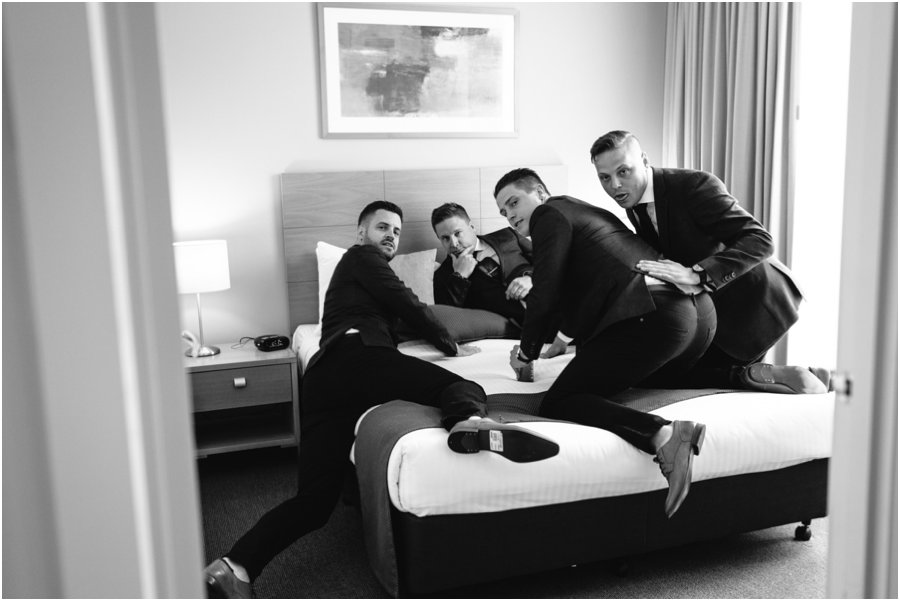 Groomsmen on a bed being silly