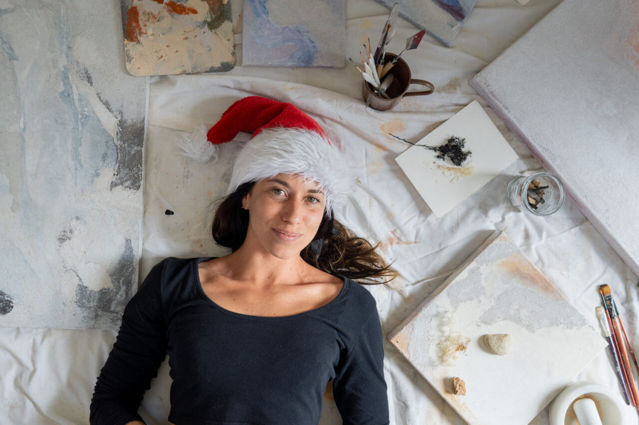 Creative Torquay personal branding portrait of artist lying among canvases