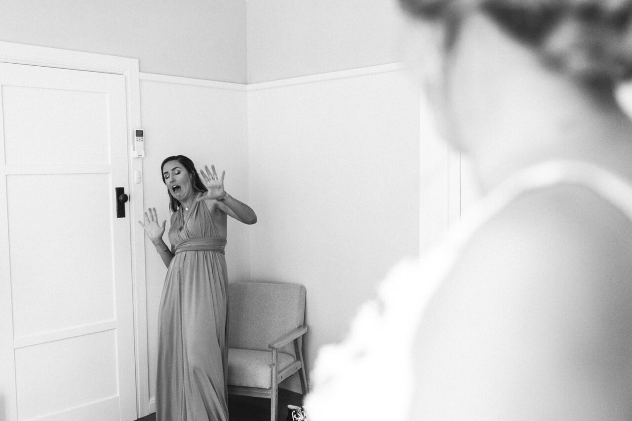 Bridesmaid reacting with surprise during first look moment on wedding morning