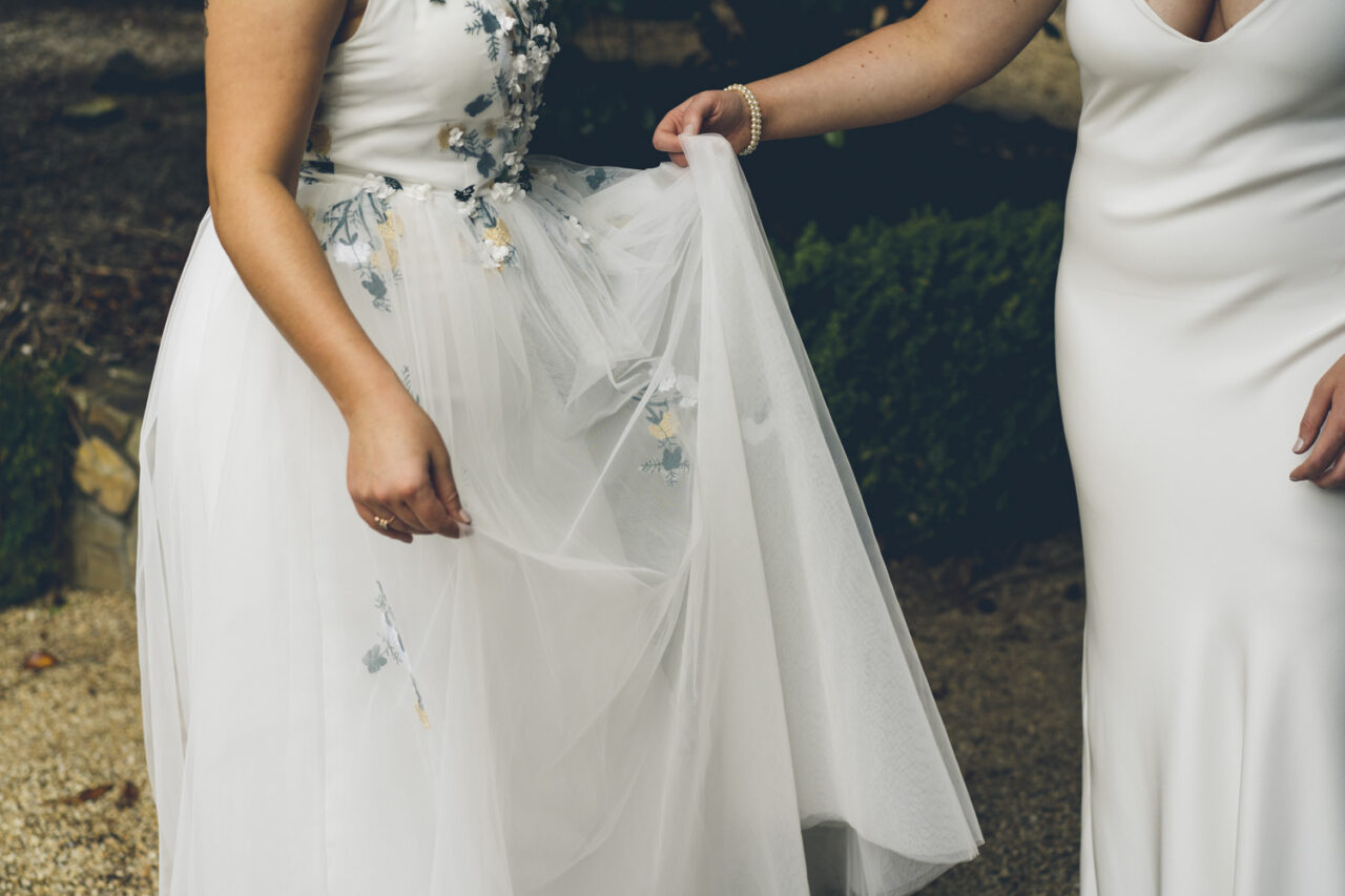 Close up of wedding dress with colourful floral embroidery and layered fabric