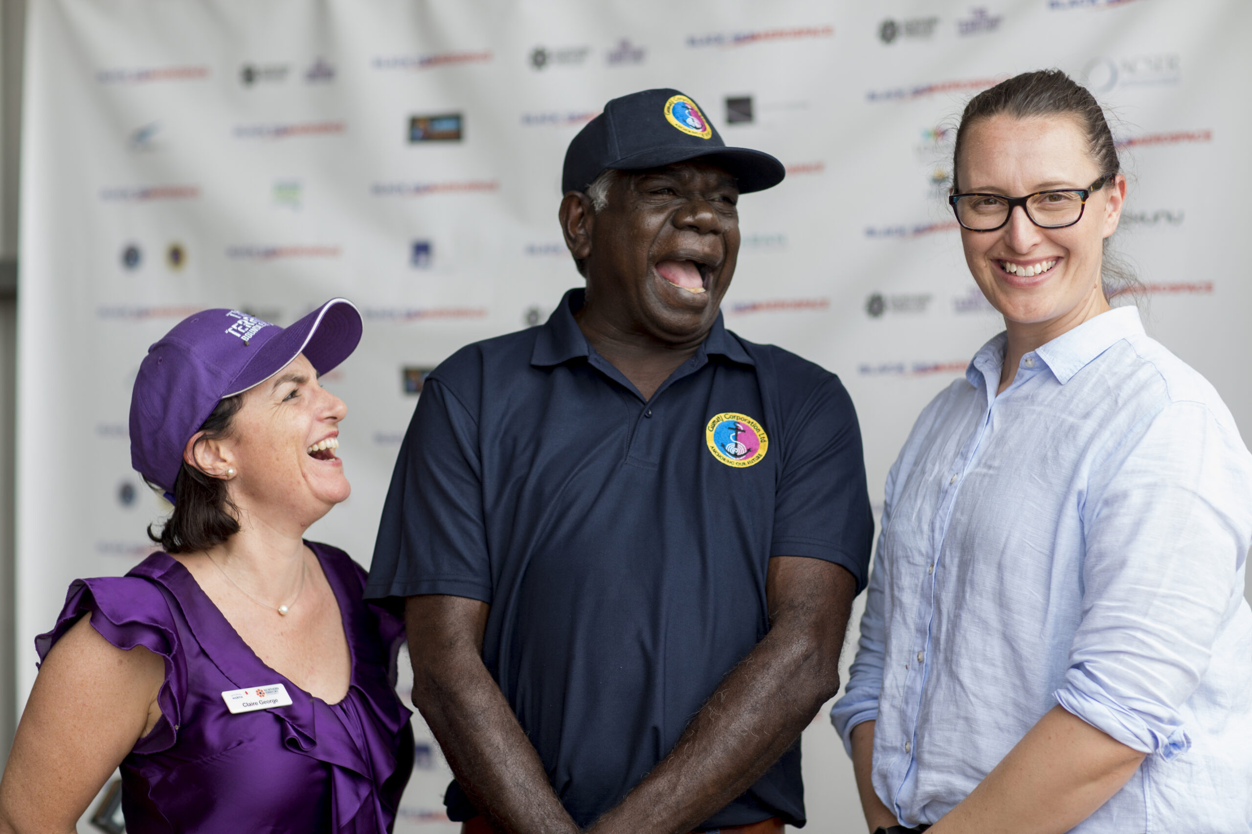 Indigenous event capturing three people laughing 