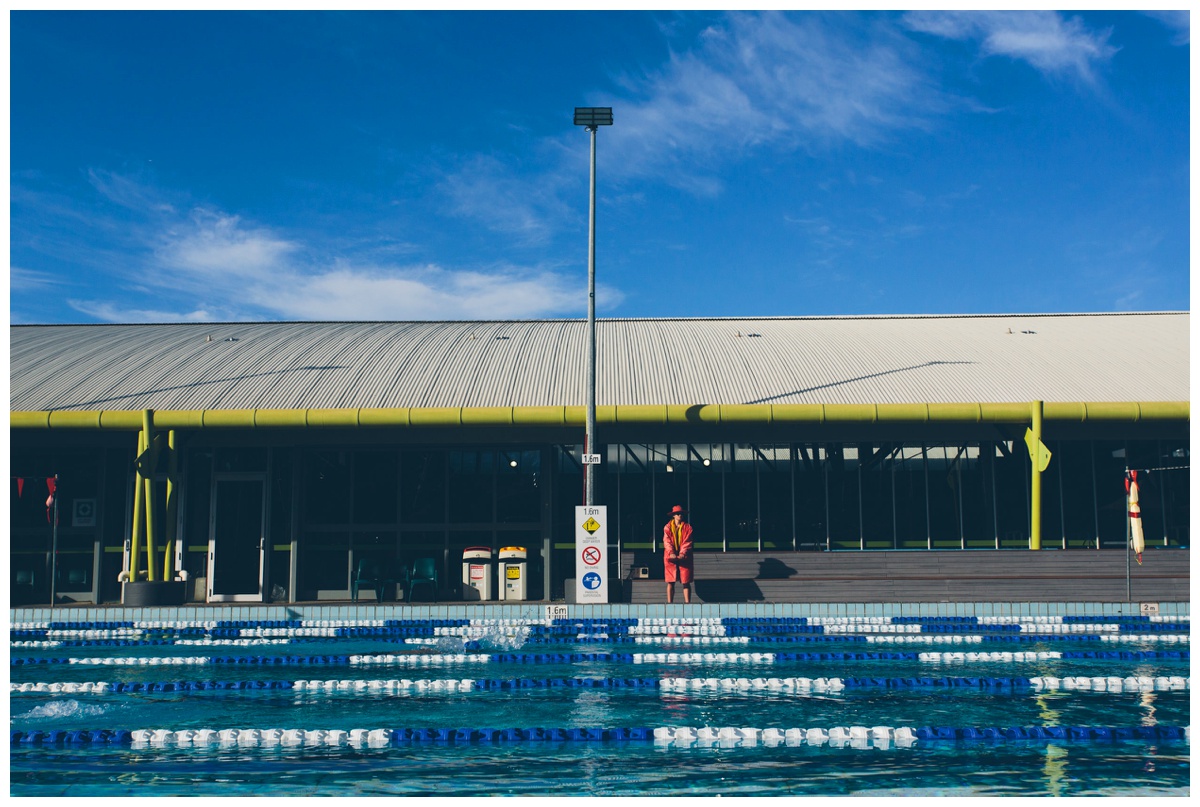 Wide shot of a pool with a life guard