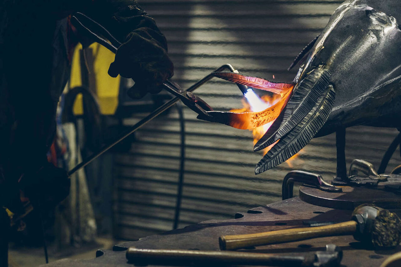 Curved steel feather shaped by hammering and bending.