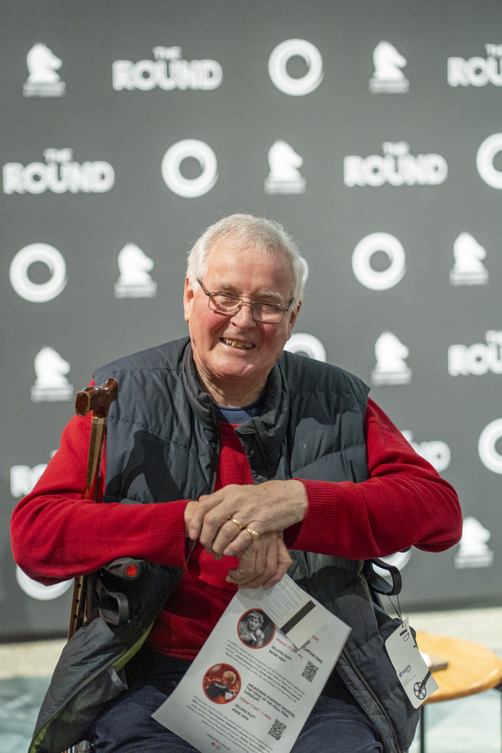 Portrait of a smiling audience member holding a theatre program at The Round Melbourne before Circa’s Duck Pond, photographed by Lauren Marshall.