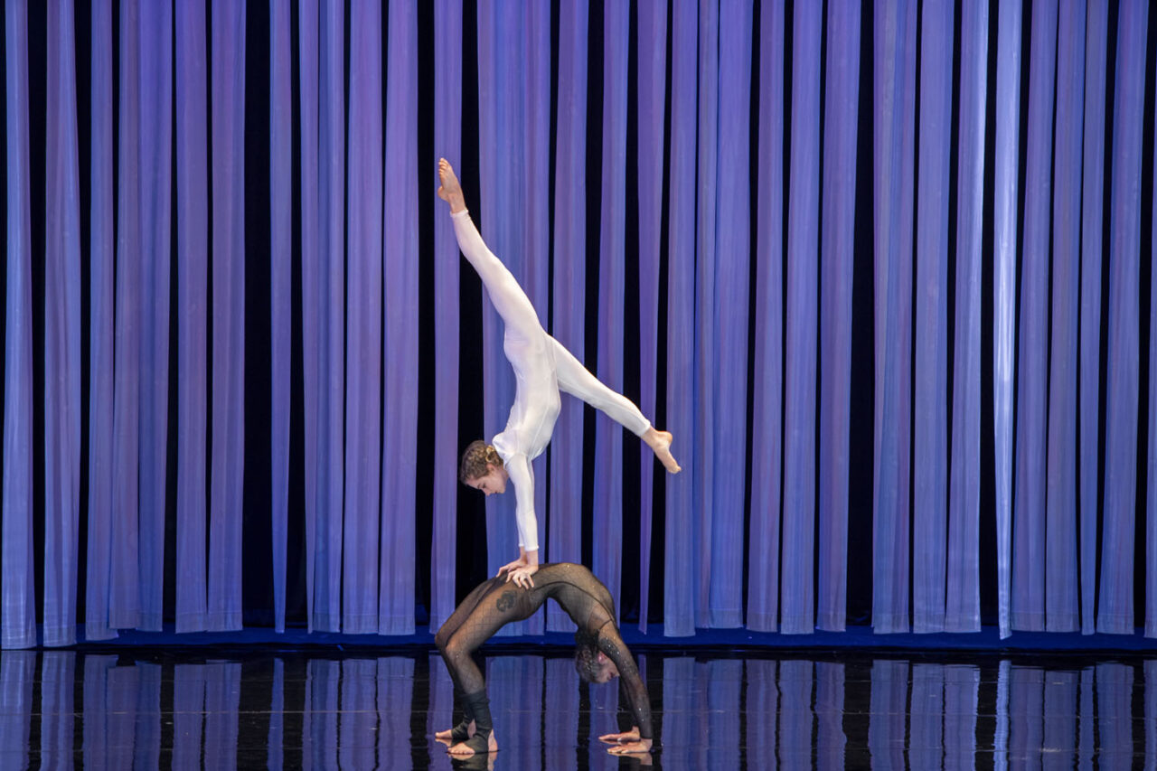 Two Circa performers balancing in a handstand formation against a blue backdrop during Duck Pond at The Round Melbourne, photographed by Lauren Marshall.
