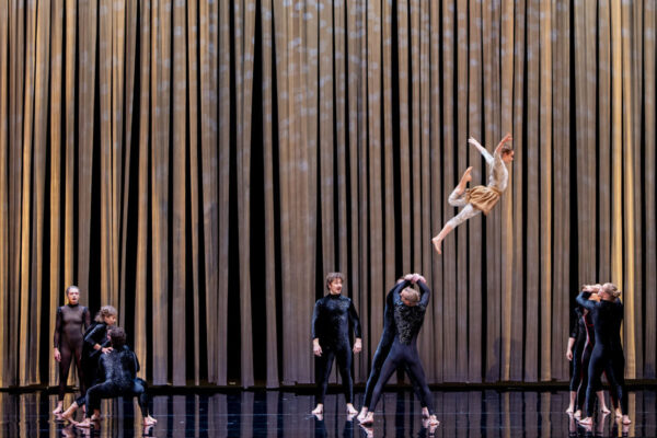 Circa performers during Duck Pond at The Round Melbourne, captured mid-air in an acrobatic lift against the golden stage backdrop.