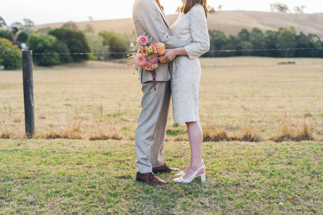 Couple walking along a country road at sunset after their wedding