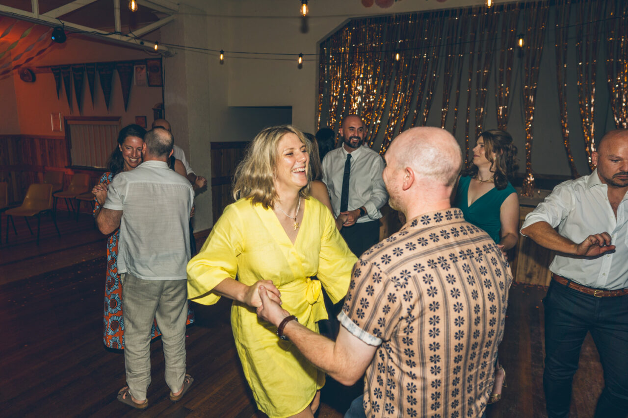 Wedding guests dancing and laughing together at the reception