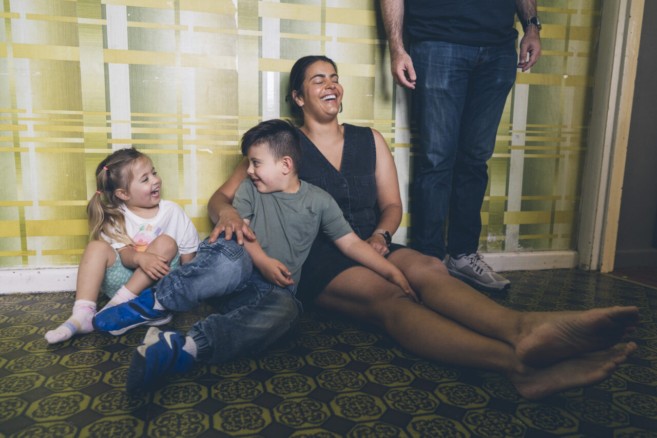 Candid moment of a mum and her two children laughing together during an in-home summer photo session on the Surf Coast