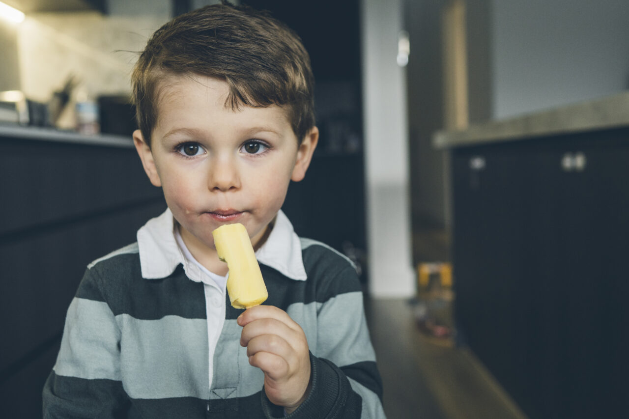 Young boy enjoying an ice cream at home during a relaxed candid summer family photo session on the Surf Coast