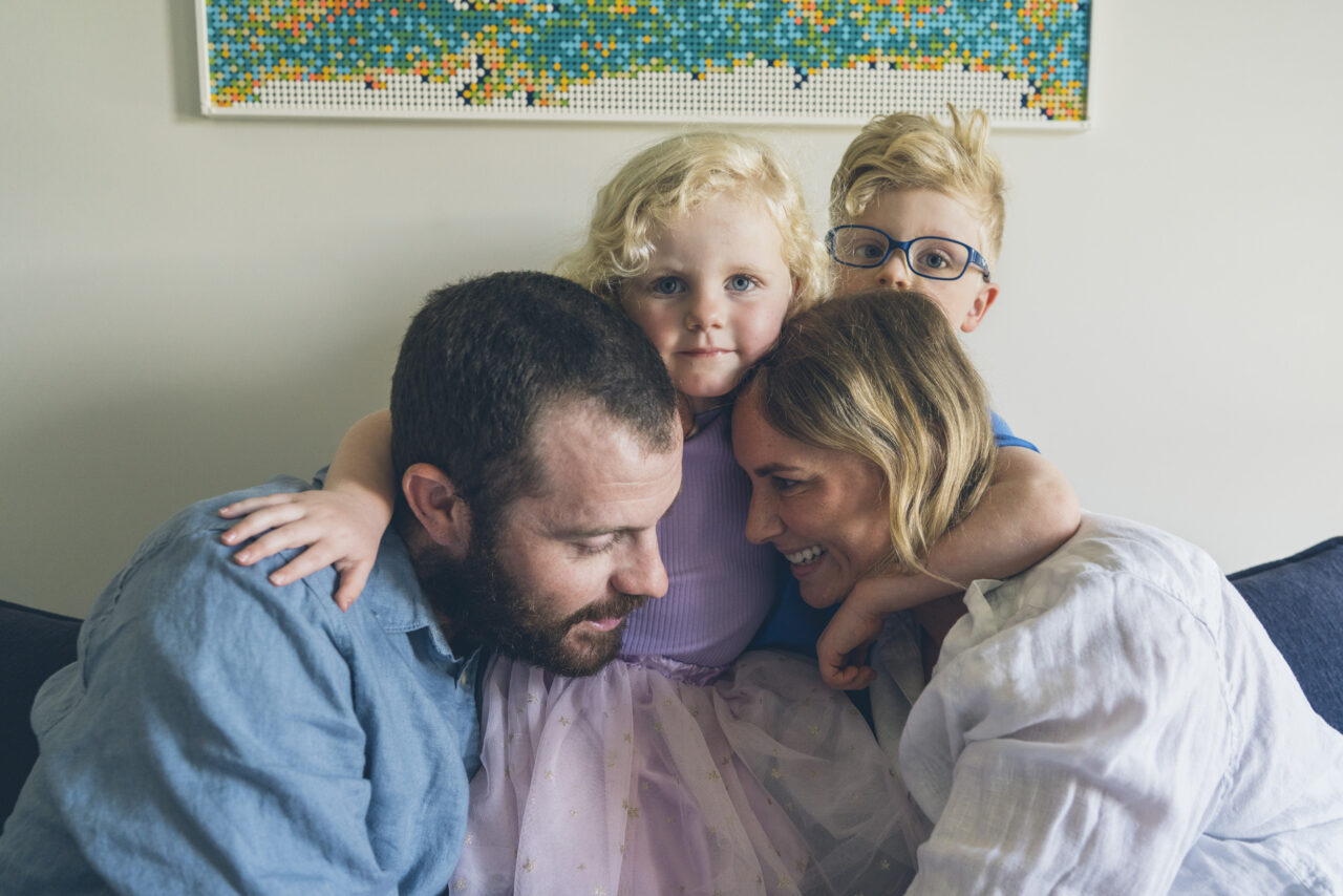 Family sharing a close cuddle at home during a candid summer photo session Surf Coast
