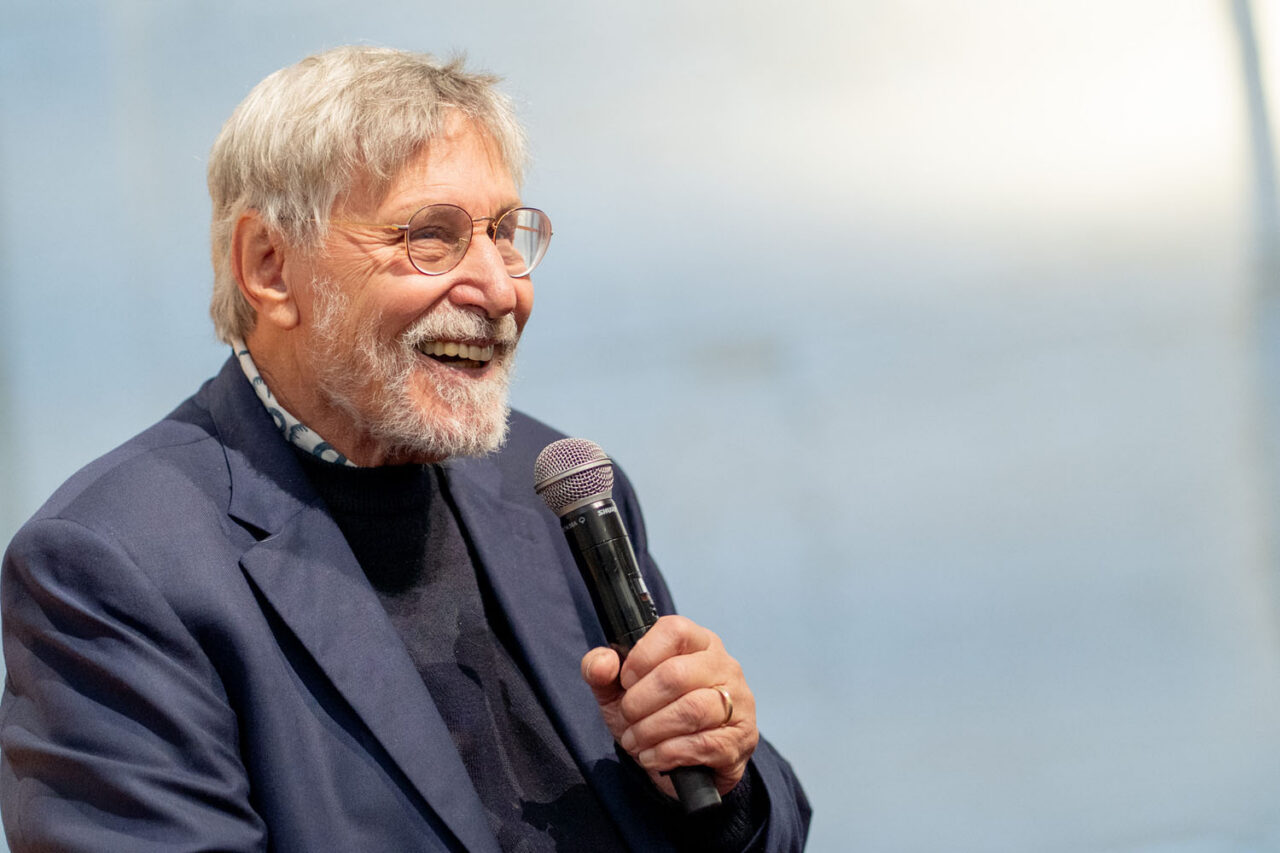 Dr Bessel Van der Kolk smiling and speaking into a microphone during a workshop talk