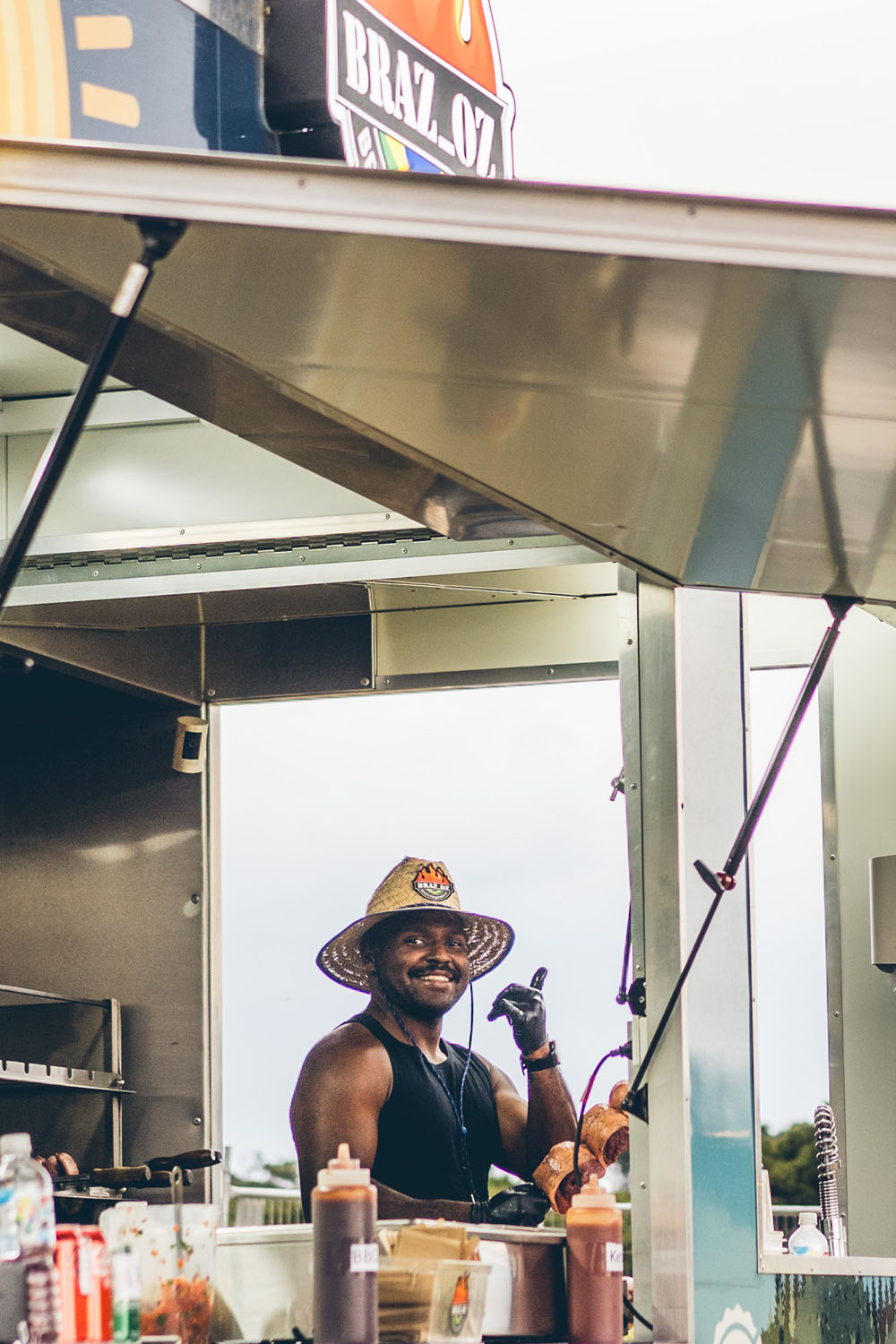 Smiling food truck vendor from Braz Oz preparing food at the NightJar festival