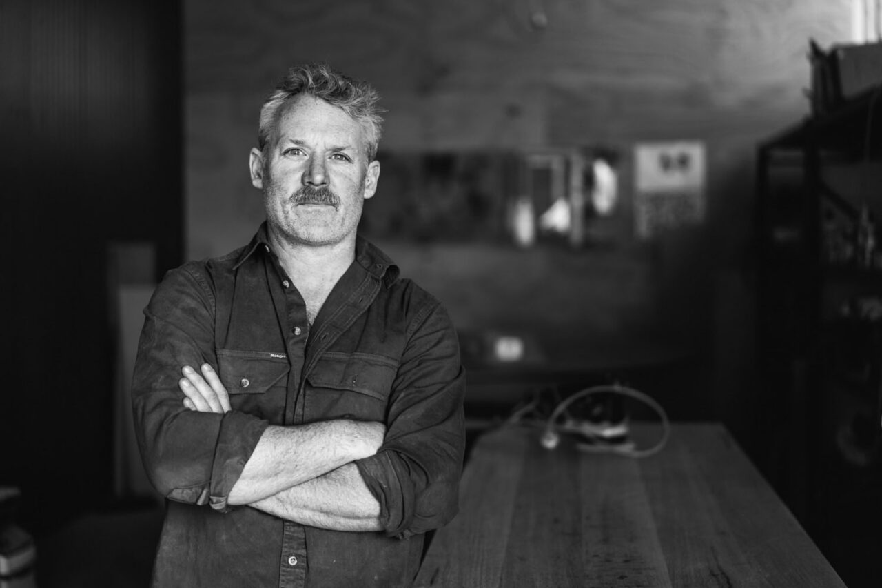 Authentic portrait of a business owner in his workspace, photographed in a documentary style