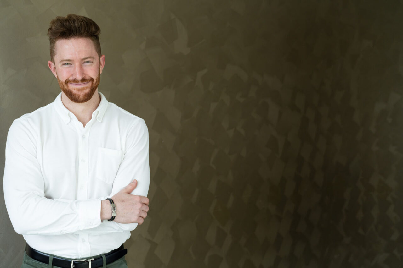 Male professional portrait in natural light against textured wall, modern corporate headshot in Melbourne.