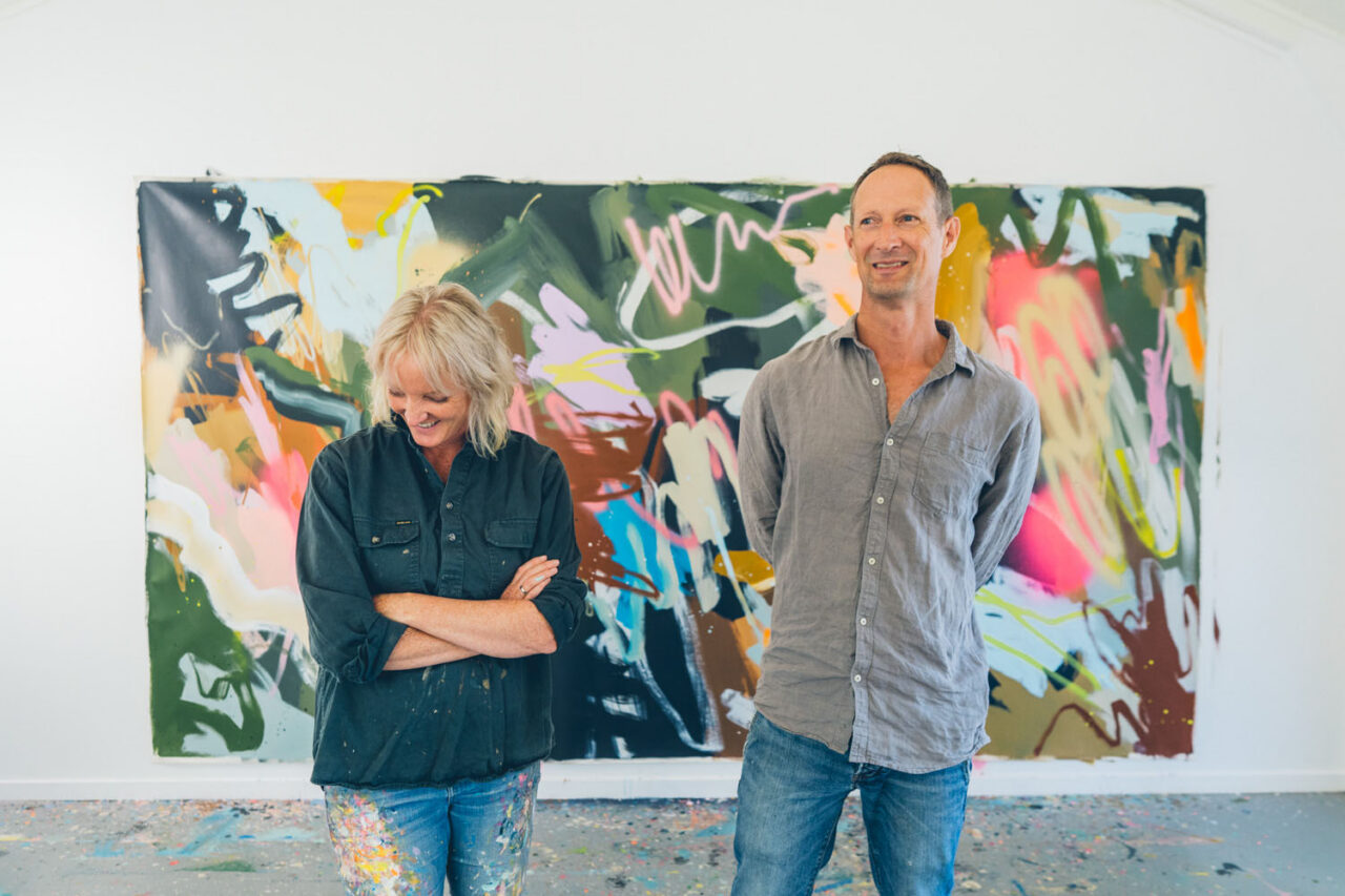 Two artists standing together in a studio, photographed to reflect creative collaboration and authentic storytelling