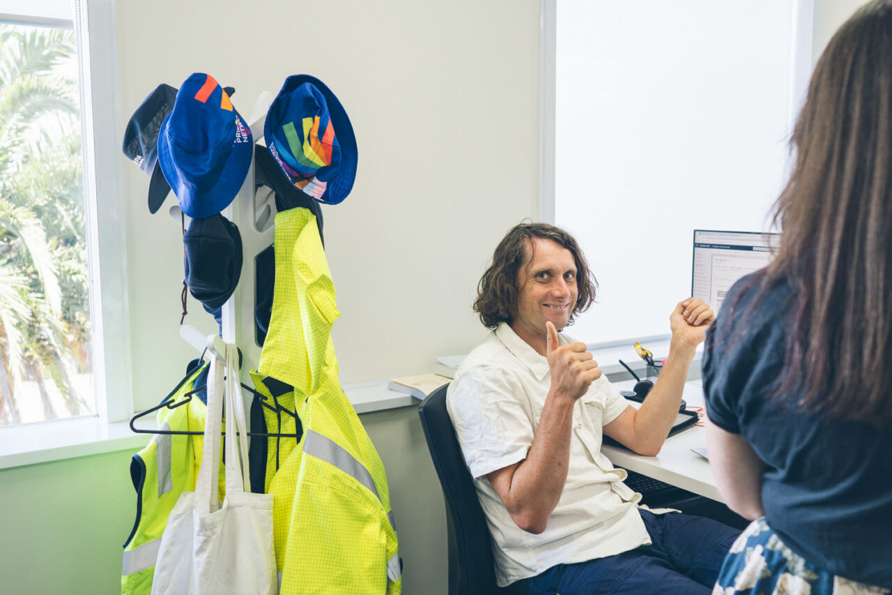 EPA Victoria staff member giving a thumbs up while working at a desk in the Preston office