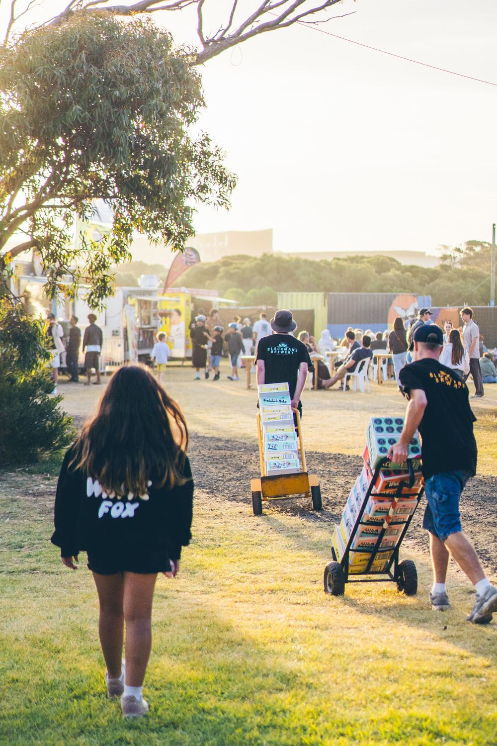 People moving stock during setup at an outdoor community event