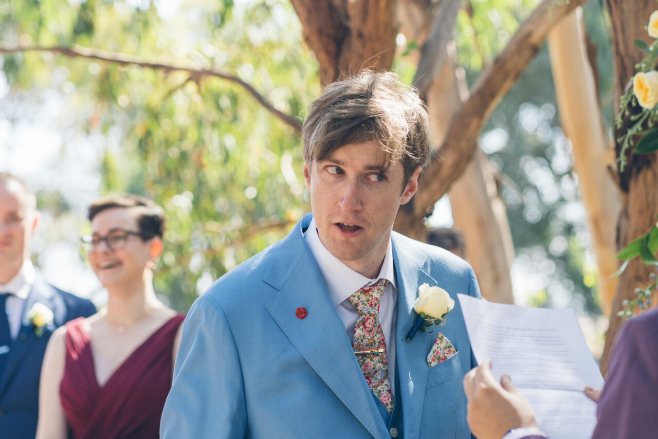 Groom reading his vows during the ceremony, emotional candid wedding moment