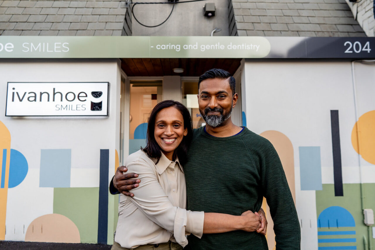 Owners standing outside Ivanhoe Smiles dental clinic smiling at the camera