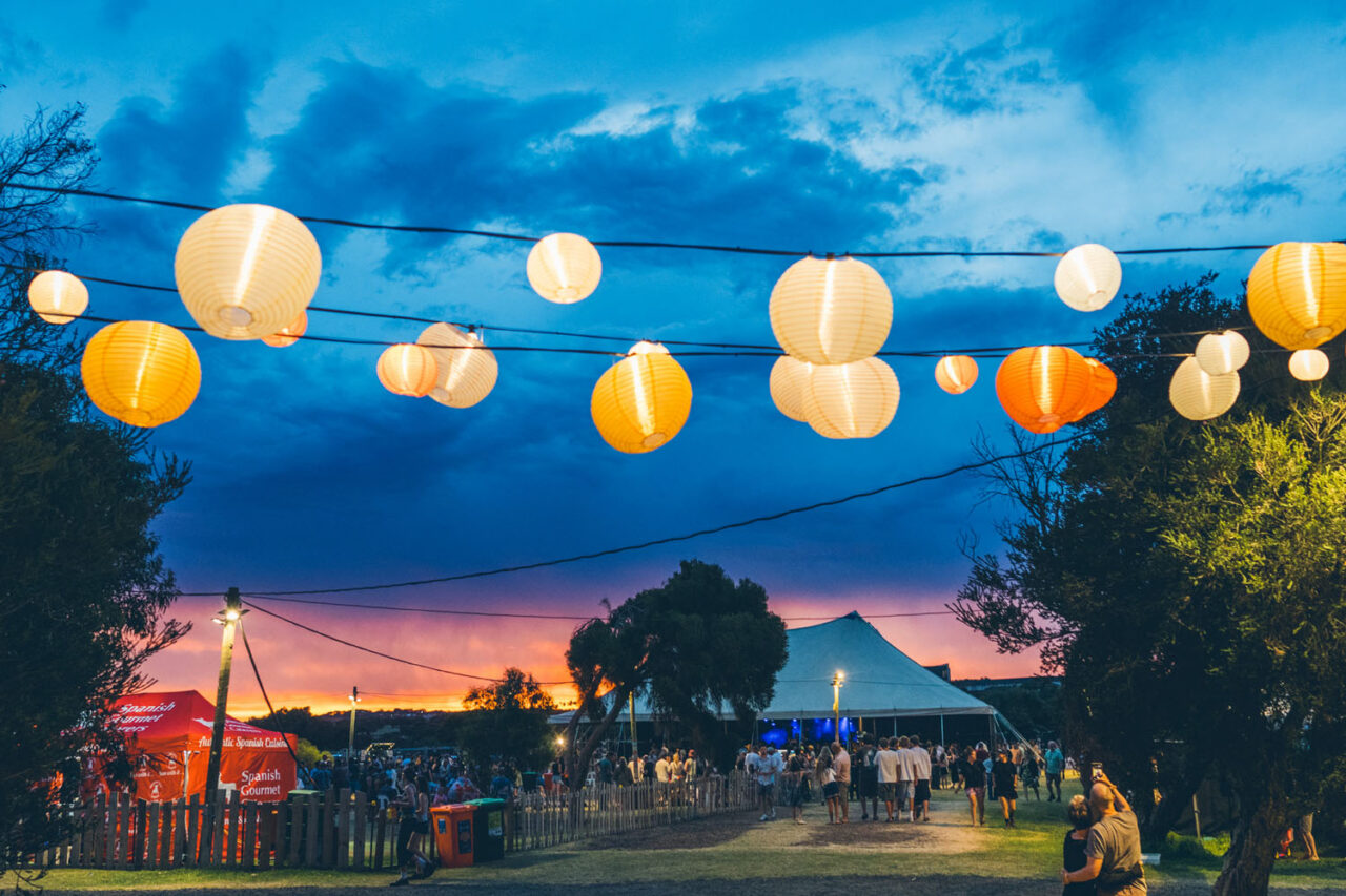 Event brand photography showing a community gathering at dusk under lantern lights