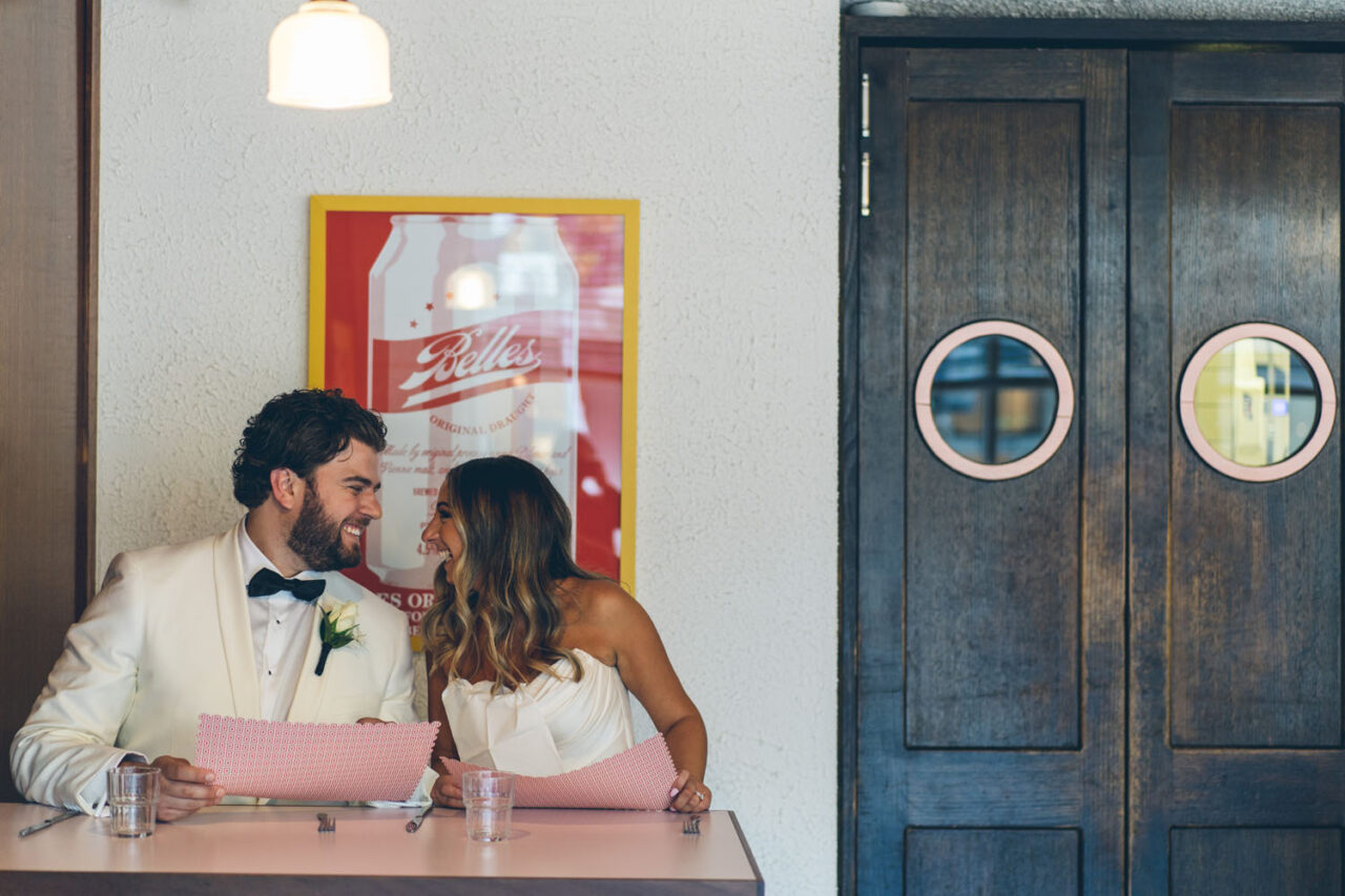 Couple laughing together in a restaurant on their wedding day