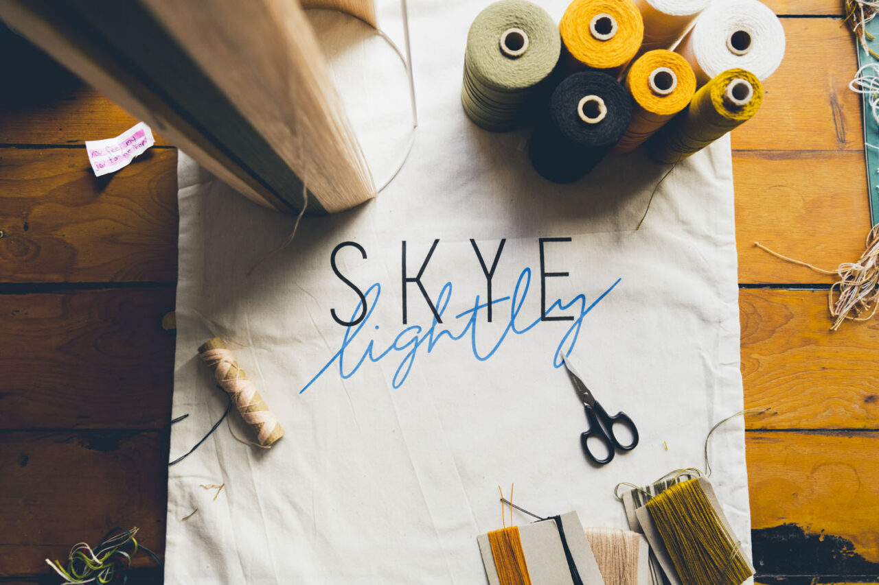 Flat lay of colourful thread spools and fabric with Skye Lightly branding, documentary brand photography capturing creative process in Melbourne