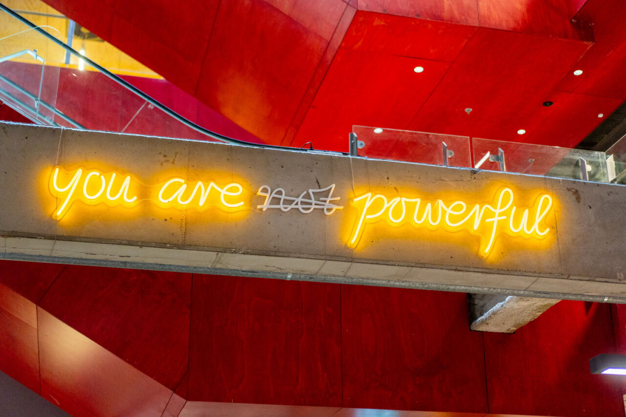 Neon sign reading “you are powerful” in a bold red interior, detail image for brand storytelling photography.