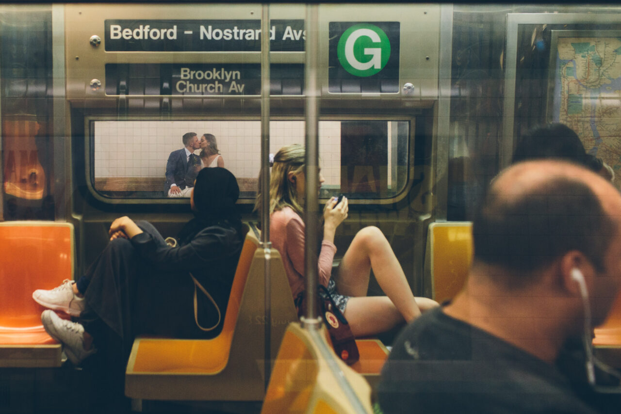 Wedding couple kissing reflected through a subway window, cinematic documentary style