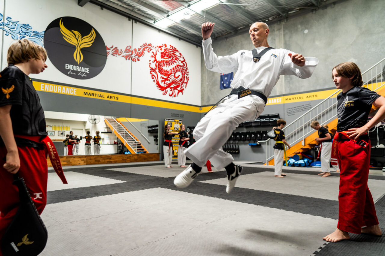 Taekwondo instructor teaching children during a class, photographed with a candid documentary approach