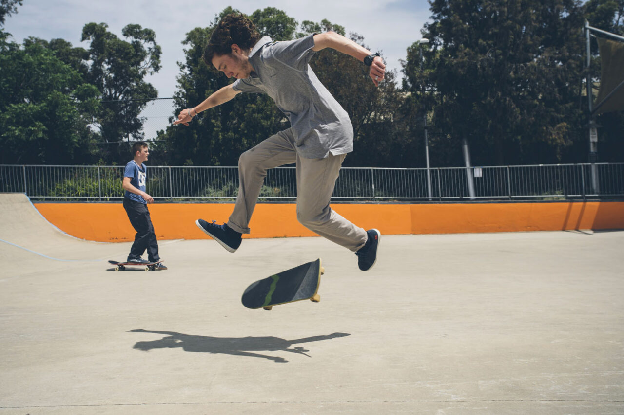 Teenager performing a skateboard trick at a local community skate park