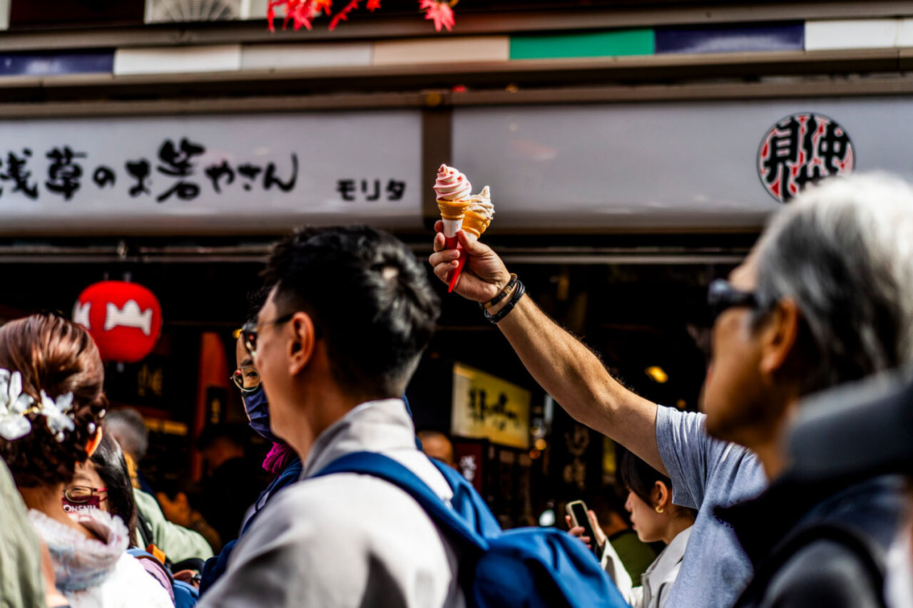 Man holding ice cream above the crowd on Nakamise Street in Asakusa, Tokyo
