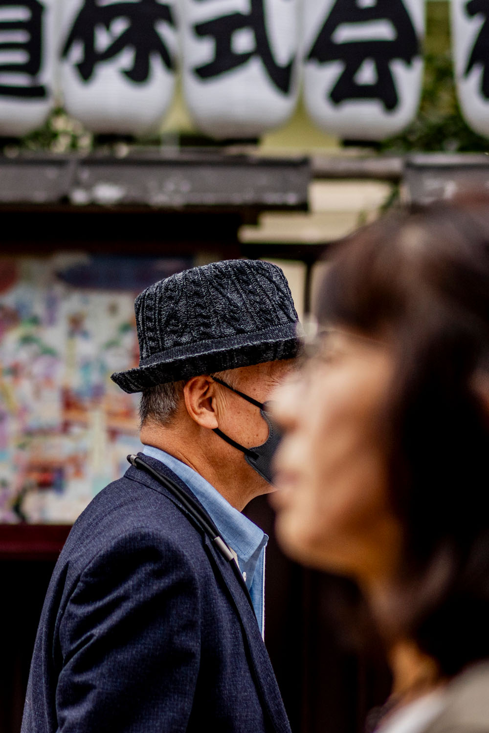 Man in a textured hat and face mask walking through Asakusa street
