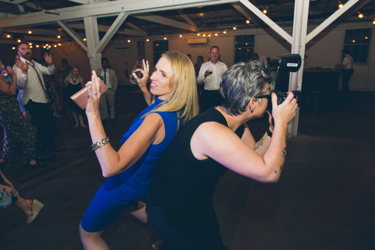 Documentary wedding photographer capturing guests dancing during a lively wedding reception.