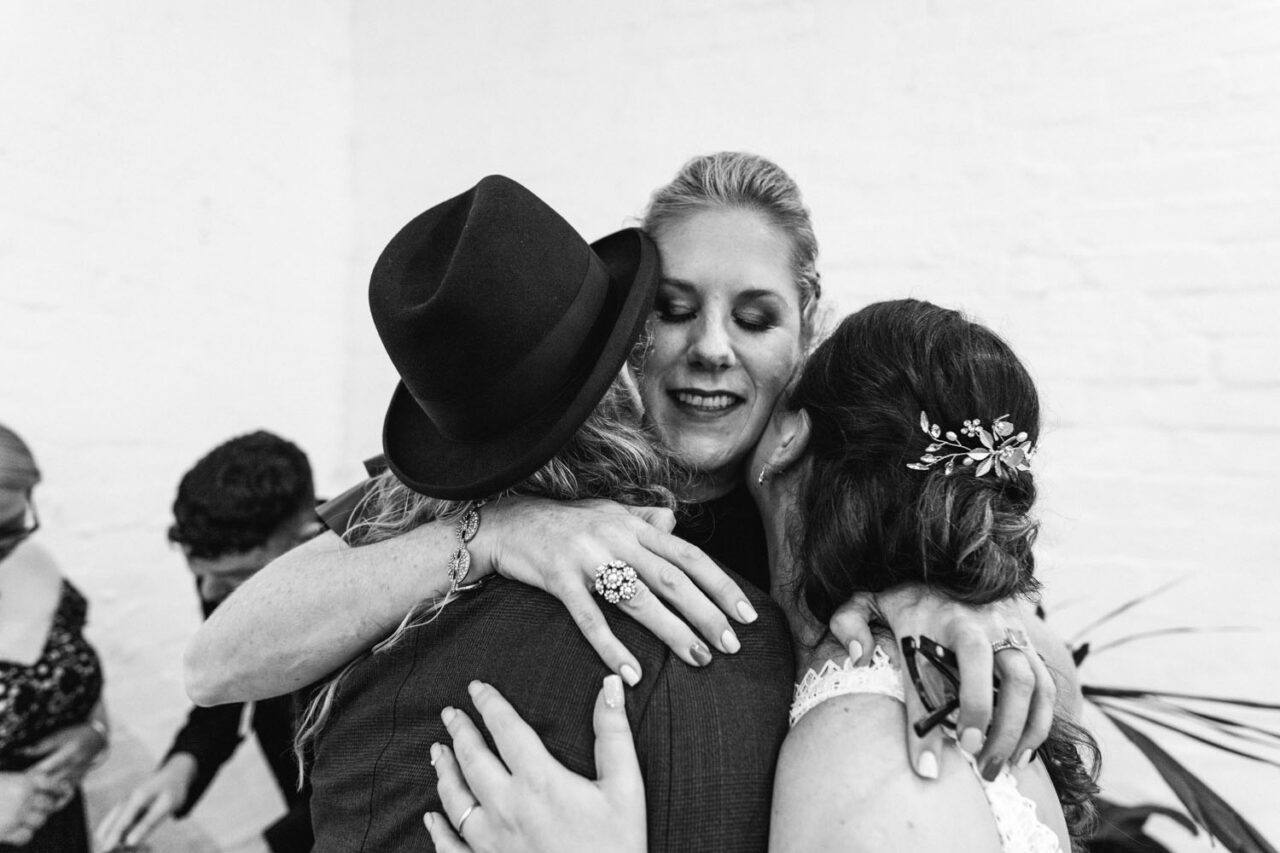 Family embracing the couple during an emotional moment at a Melbourne wedding.