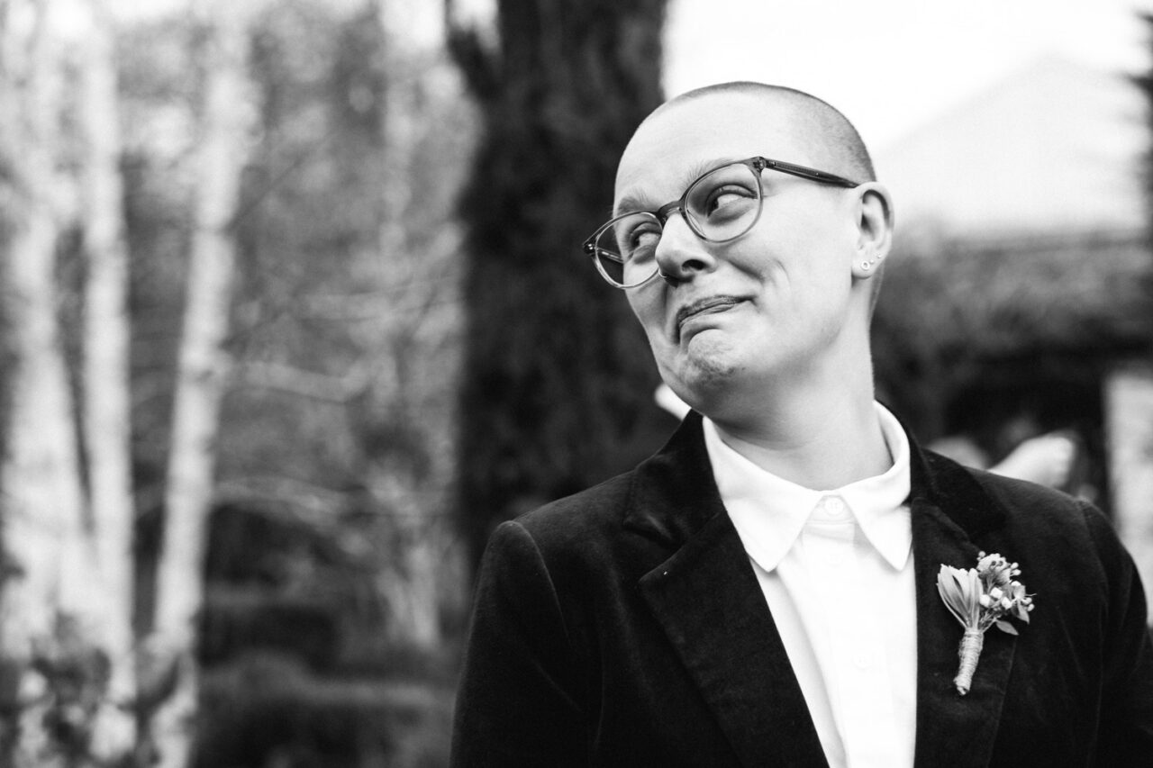 Black and white portrait of Naomi in a suit with boutonniere during her Daylesford wedding.
