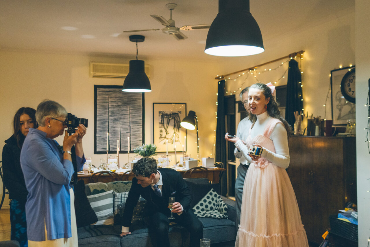 Guest giving an emotional speech inside a candlelit Airbnb during an intimate Daylesford wedding.
