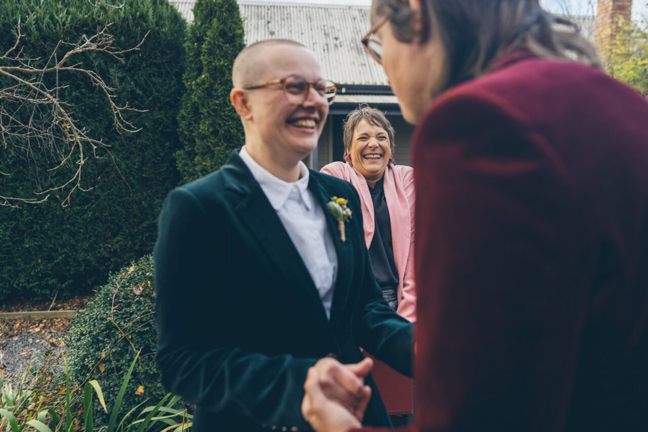 Dee Wild excited during a first look moment in a garden at a Daylesford wedding.