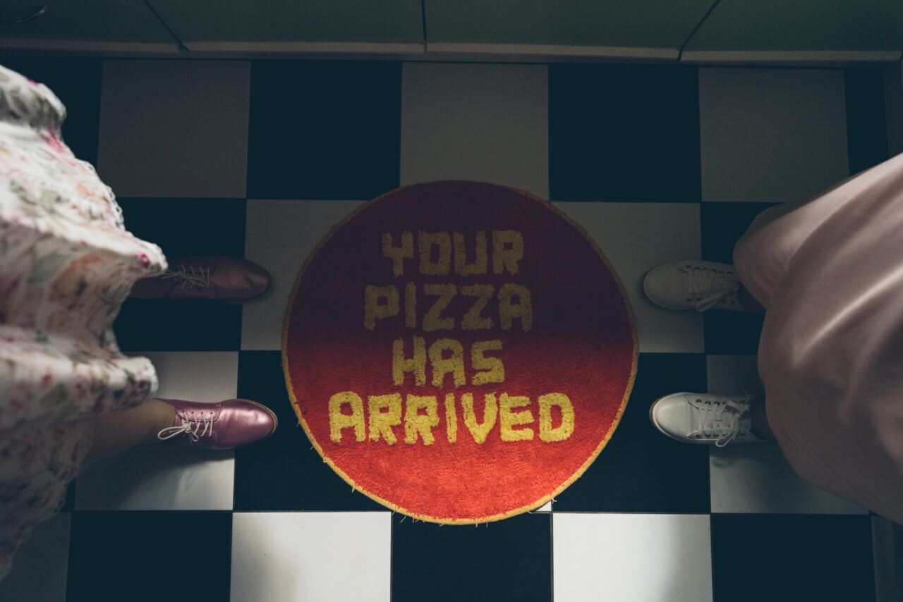 Your pizza has arrived” mat at a Happy Camper Pizza wedding catering station in Melbourne