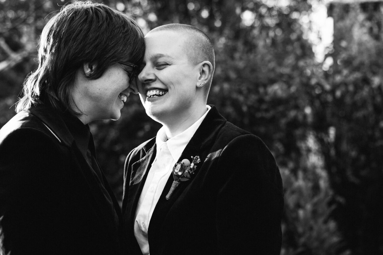 Naomi and Bec touching foreheads and smiling during portraits at their Daylesford wedding.
