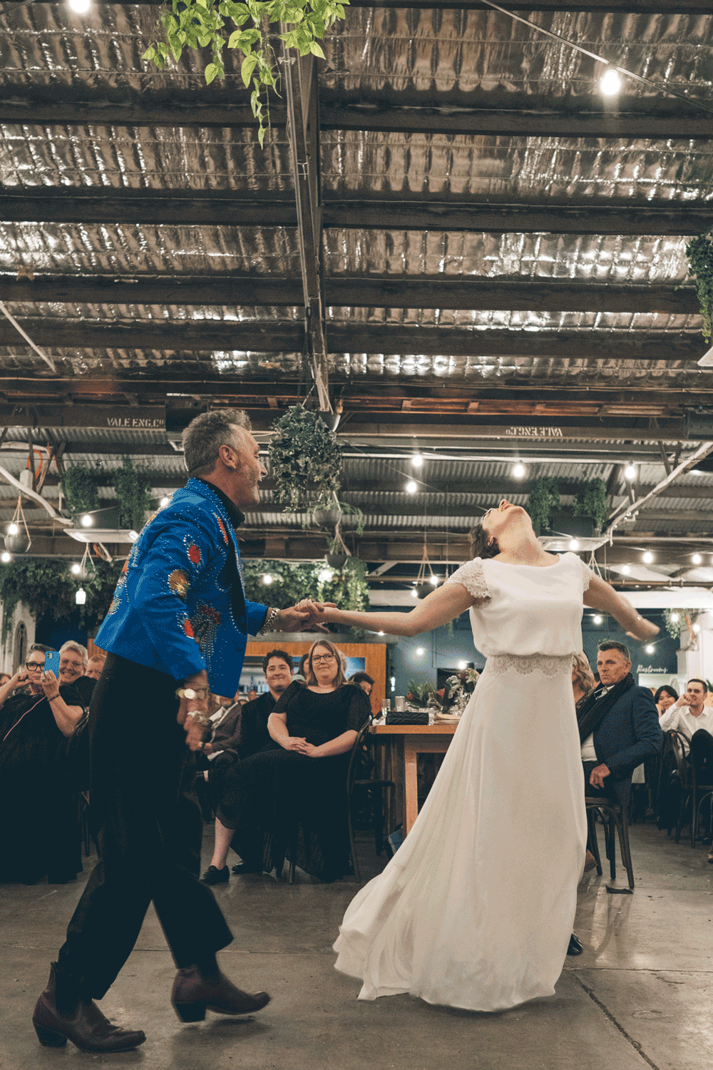 Bride dancing joyfully with her father during a wedding reception in Melbourne.