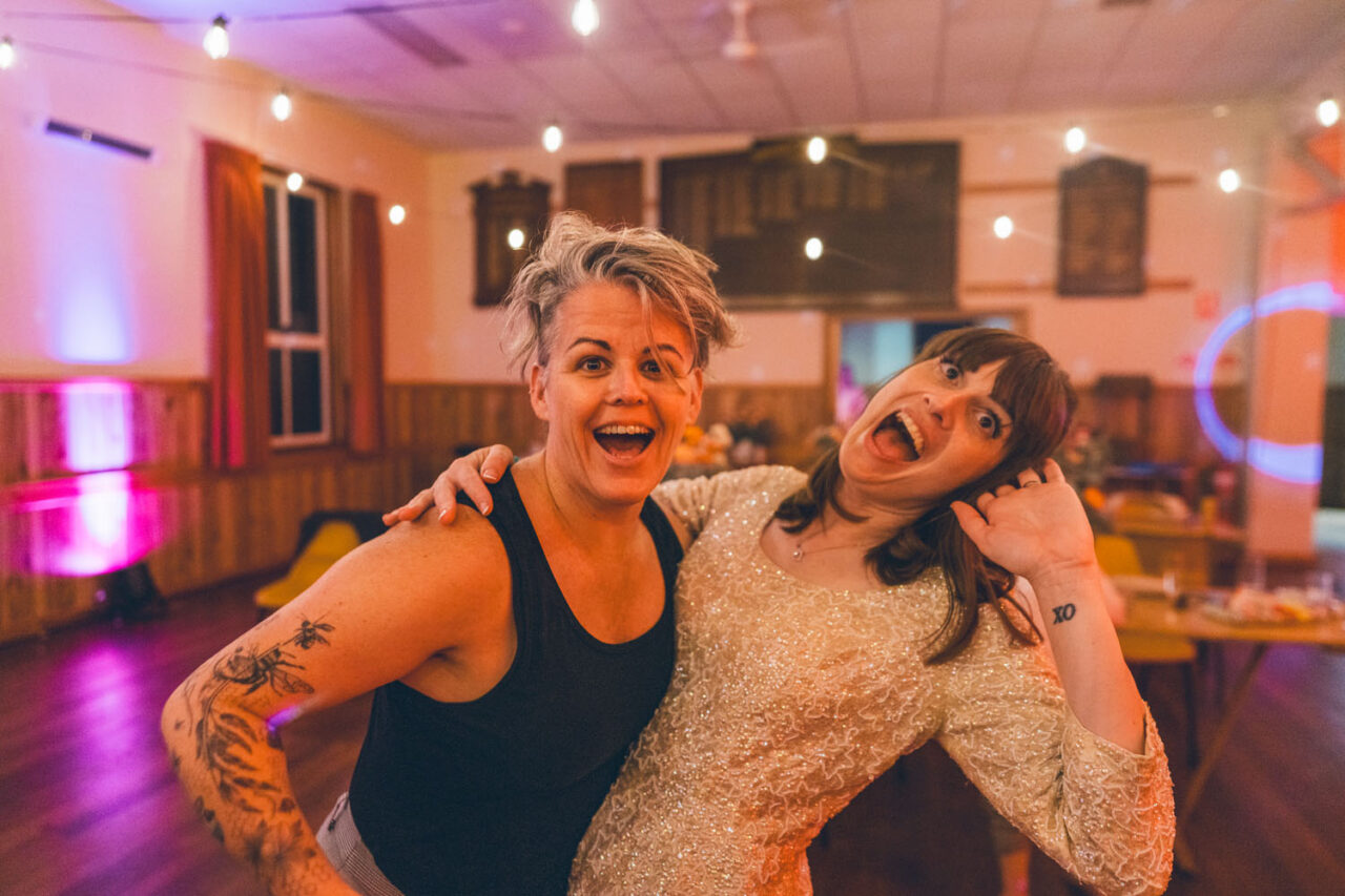 Wedding photographer celebrating with a couple during their reception on the dance floor.