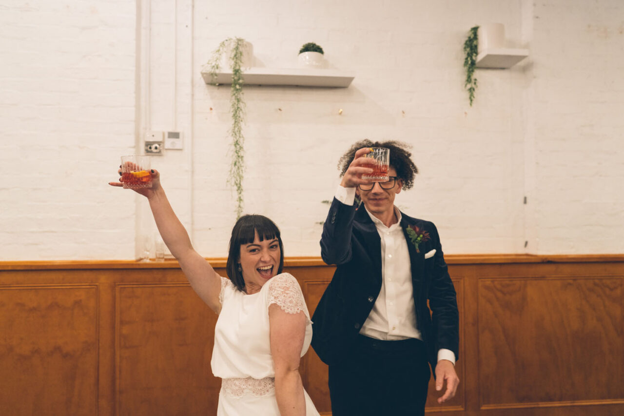 Couple raising drinks and celebrating during their wedding reception in Melbourne.