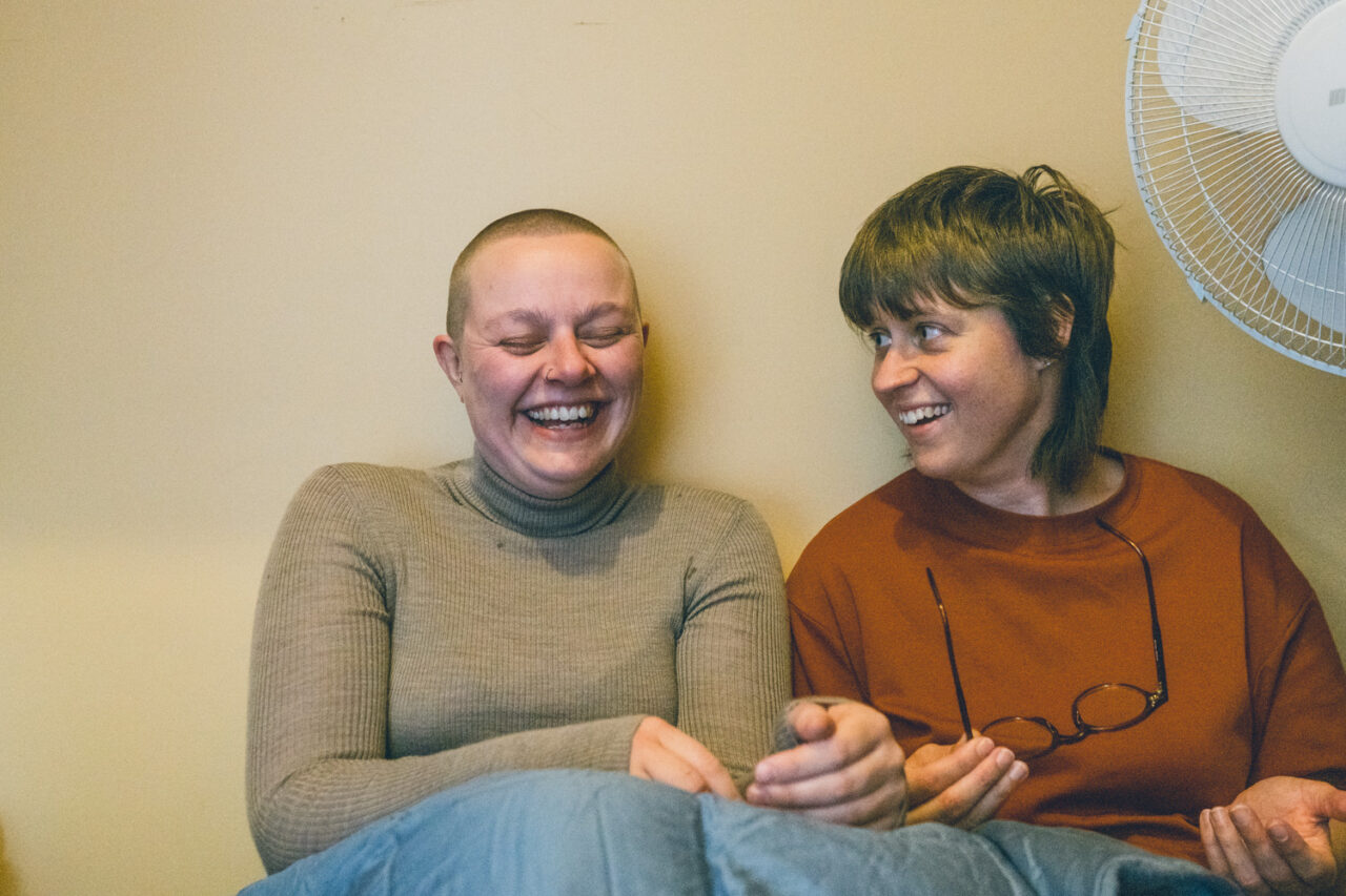 Naomi and Bec laughing together before their Daylesford wedding ceremony.
