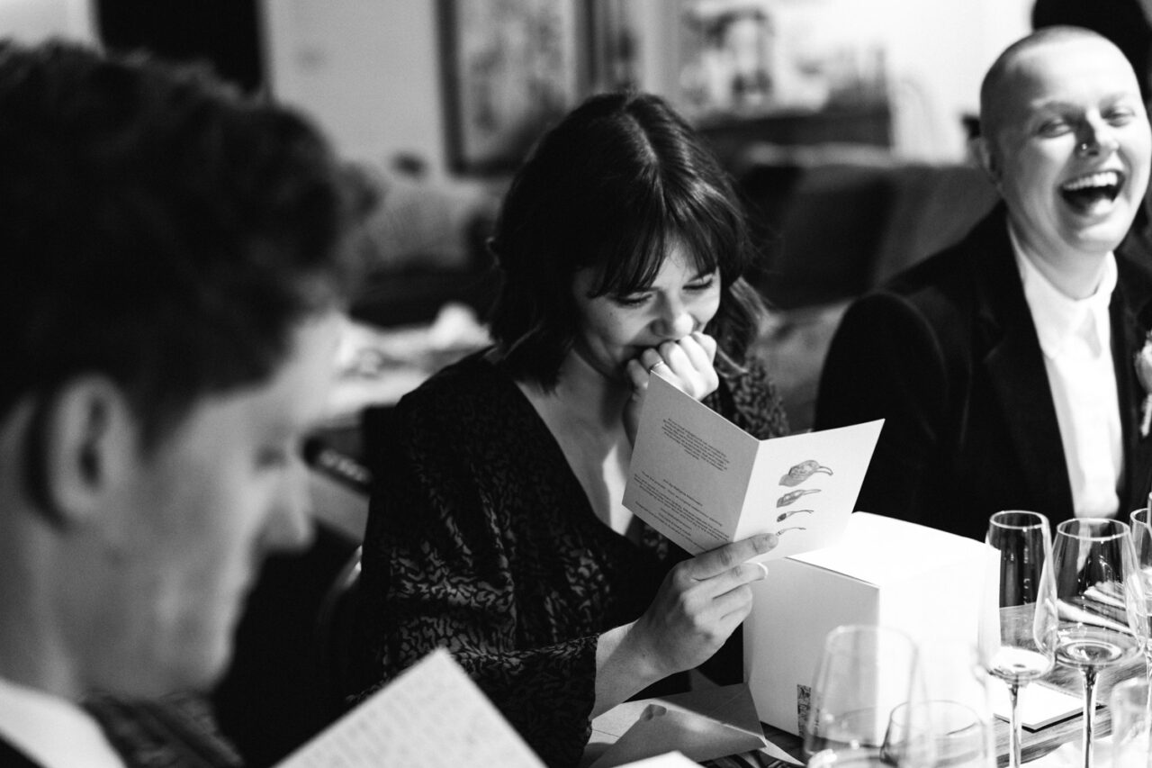 Guest reading a card at the dinner table during an intimate wedding reception in Daylesford.