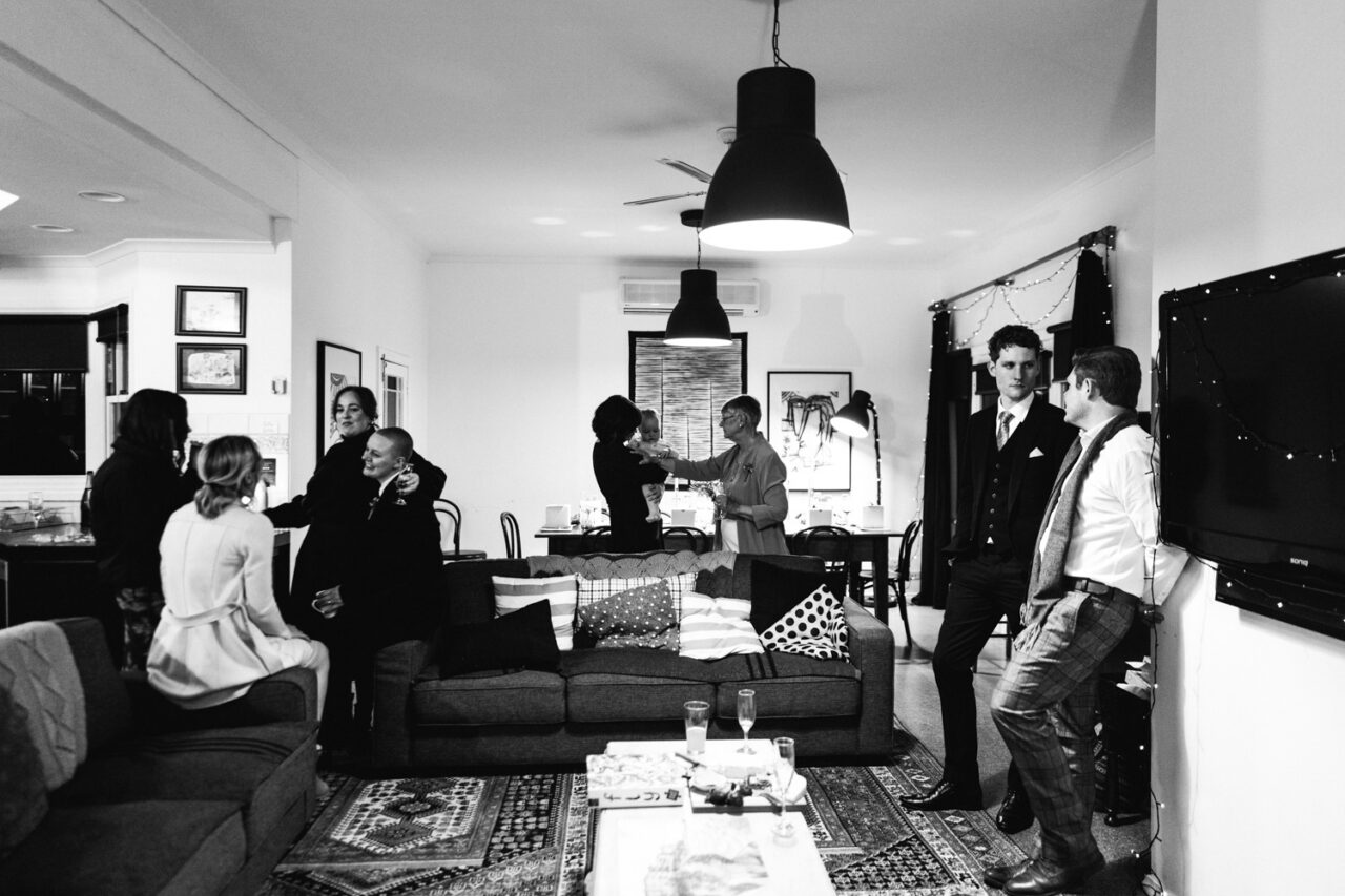 Guests chatting and relaxing inside an Airbnb during an intimate Daylesford wedding celebration.