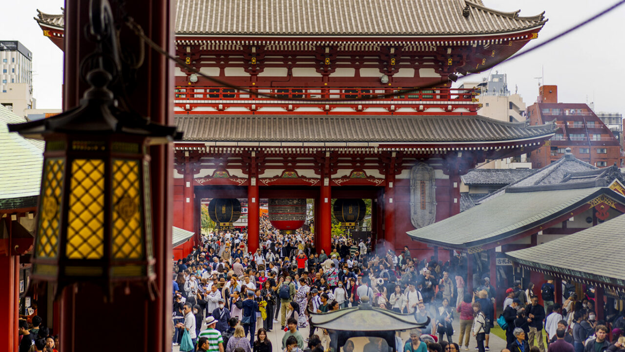 Crowds walking toward Sensoji Temple in Asakusa Tokyo on a busy afternoon