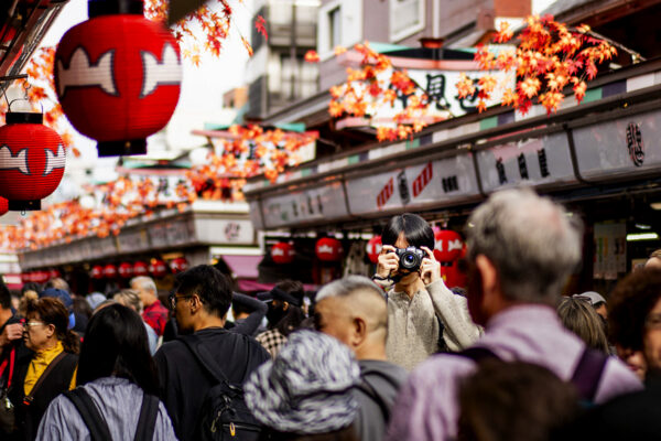 Capturing a photographer in the Crowd as people walk around Asakusa Tokyo on a busy afternoon