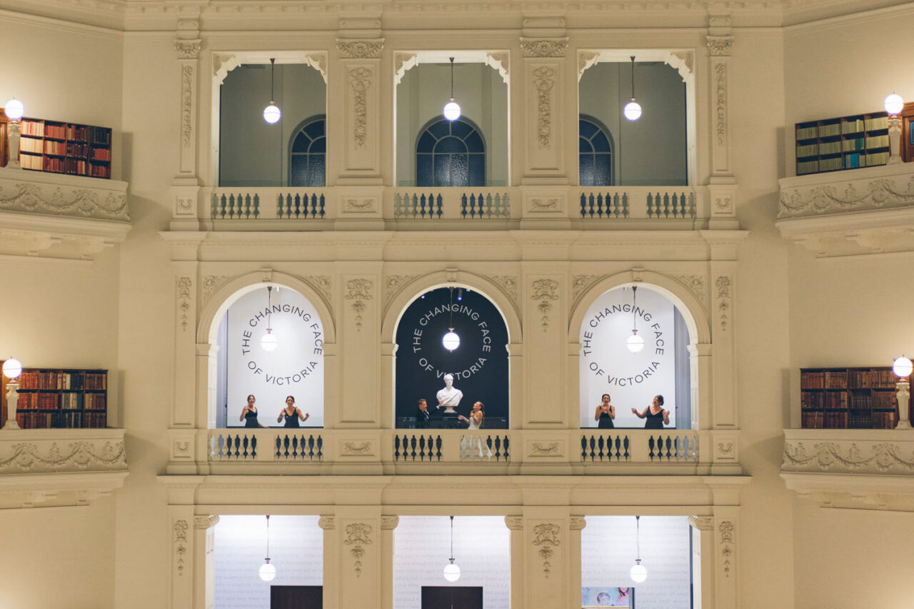 Wedding guests celebrating from the balconies inside State Library Victoria in Melbourne.