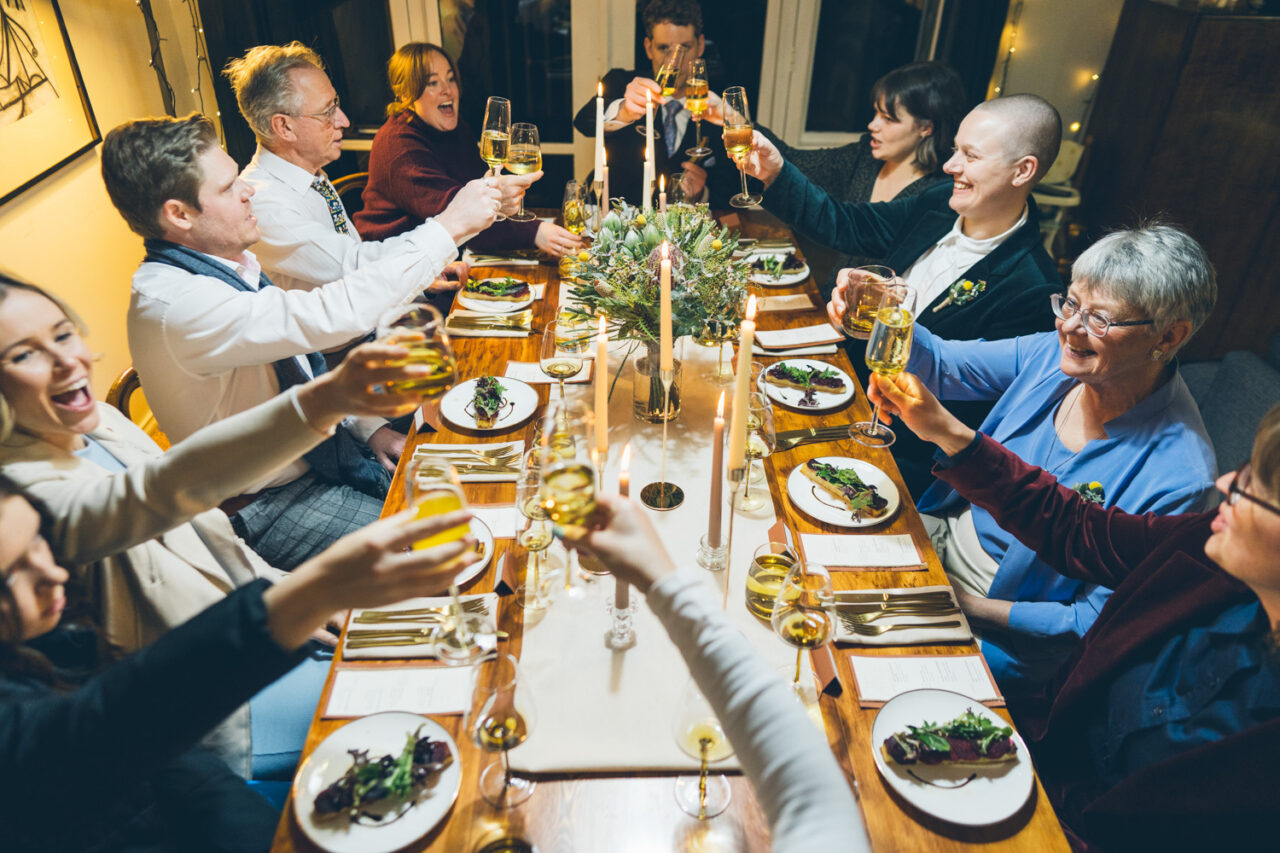 Guests raising glasses in a toast at a candlelit wedding dinner in Daylesford.